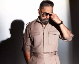 Actor in a beige outfit and sunglasses posing for a promotional photo for Indian 2.