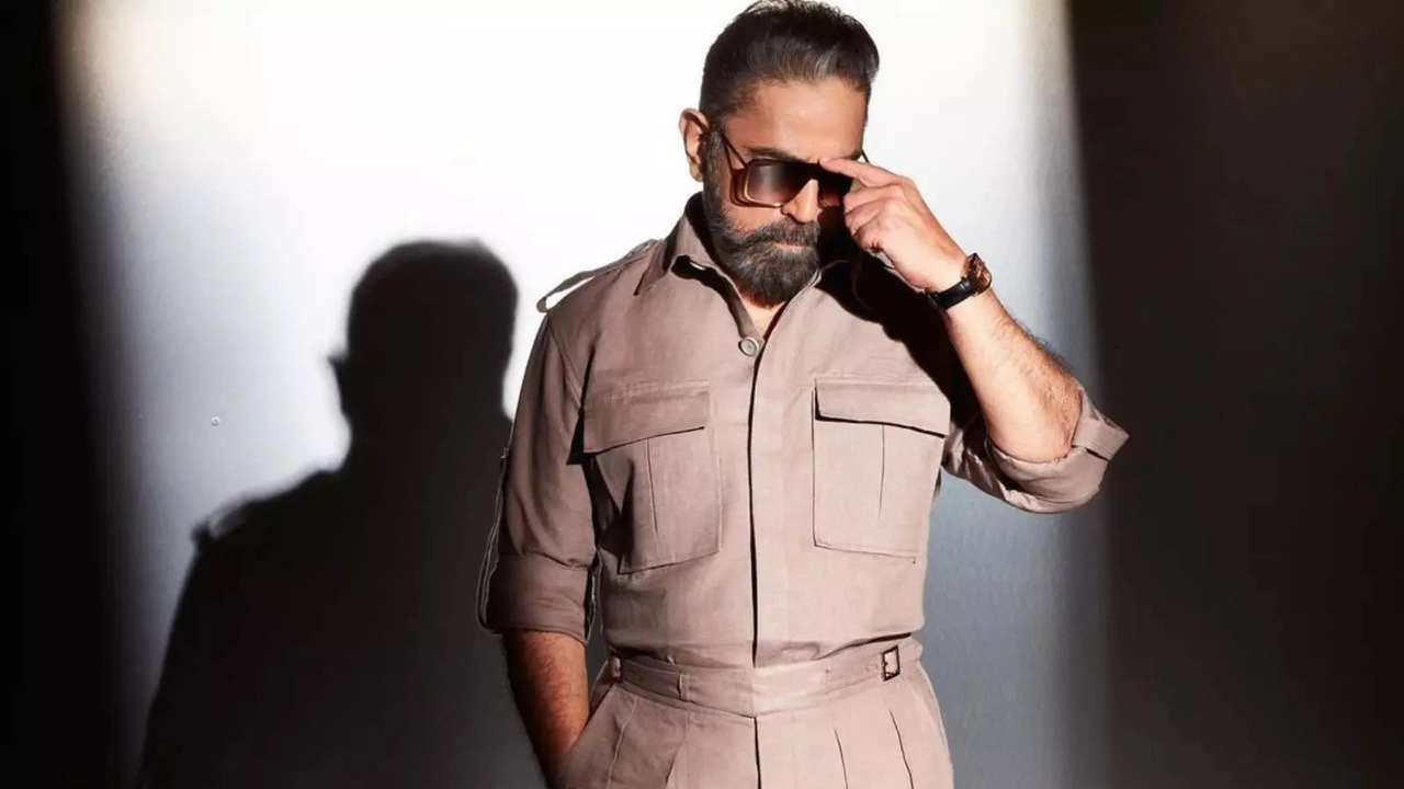 Actor in a beige outfit and sunglasses posing for a promotional photo for Indian 2.
