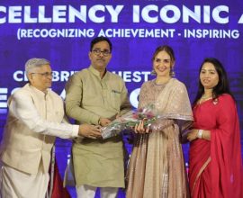 Four individuals standing on a stage during an award ceremony, with one person handing a bouquet to another at Bizz Expo & Summit .