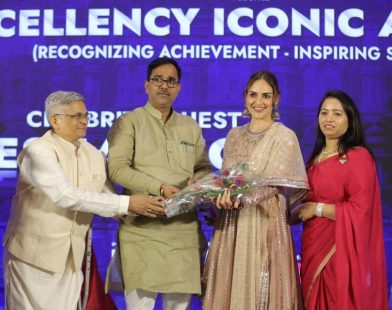 Four individuals standing on a stage during an award ceremony, with one person handing a bouquet to another at Bizz Expo & Summit .