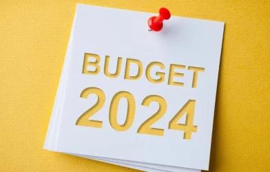 A white note with "BUDGET 2024" written in bold letters and pinned to a yellow background.